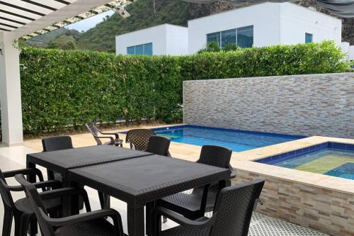 a patio with a table and chairs next to a swimming pool at Condo Apulo - Hermosa casa - Jacuzzi y Piscina privados - WiFi in Apulo