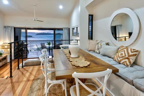 a living room with a couch and a table with a mirror at Panorama Apartments on Hamilton Island by HIHA in Hamilton Island