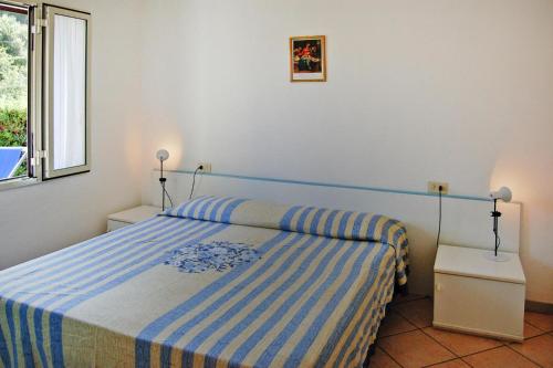 a bedroom with a blue and white bed and a window at Apartment in Capoliveri near Sea Beach in Capoliveri