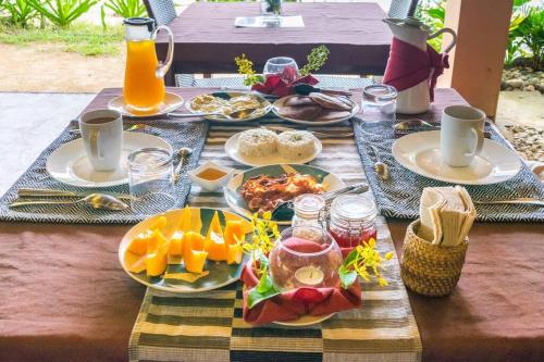 une table avec des assiettes de nourriture et de boissons dessus dans l'établissement Elnido TERRA NOVA BEACH RESORT Sunset Villa, à El Nido