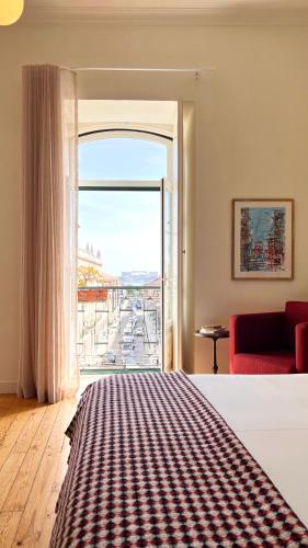 a hotel room with a bed and a large window at Casa do Bairro by Shiadu in Lisbon