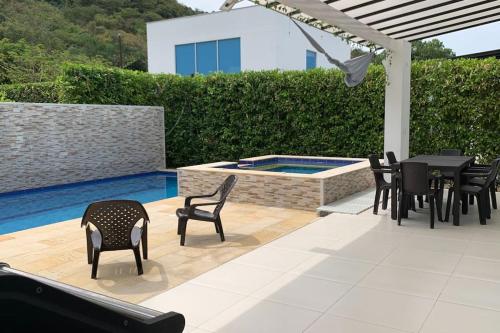 a patio with chairs and a table and a swimming pool at Condo Apulo - Hermosa casa - Jacuzzi y Piscina privados - WiFi in Apulo