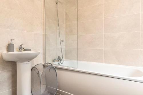 ein Bad mit einer Badewanne, einem Waschbecken und einer Dusche in der Unterkunft 3-bedroom Home in Liverpool L15 with FREE Parking in Liverpool