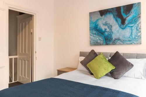a bedroom with a bed and a painting on the wall at 3-bedroom Home in Liverpool L15 with FREE Parking in Liverpool