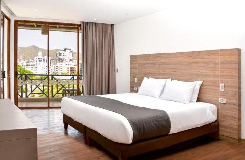 a bedroom with a large bed and a large window at HOTEL KARAYA DIVE RESORT in Santa Marta