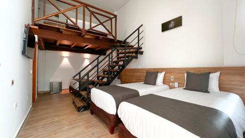 a bedroom with two beds and a spiral staircase at HOTEL KARAYA DIVE RESORT in Santa Marta