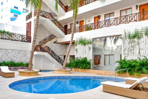 un hotel con piscina y palmeras en HOTEL KARAYA DIVE RESORT, en Santa Marta