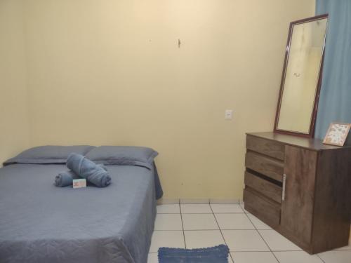 ein Schlafzimmer mit einem Bett, einer Kommode und einem Spiegel in der Unterkunft Studio 33 próximo ao Centro in Palmas
