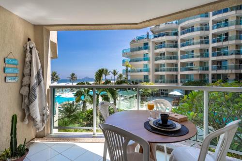 un balcone con tavolo e sedie e un edificio di Vista Mar - Resort Carioca - WIFI 500Mb a Rio de Janeiro