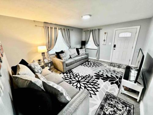 sala de estar con sofá y mesa en Stylish Cape Cod Cutie All Queen Beds 13 Min to downtown, en Cincinnati