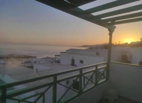 a view of the sunset from a balcony of a building at Great Ocean View and Lobos & Fuerteventura Islands in Tías