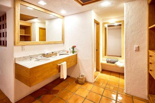 uma casa de banho com um lavatório e um espelho em Two bdr beachfront with jacuzzi em Careyes