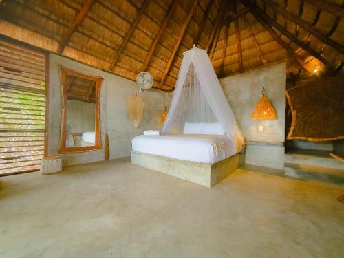um quarto com uma cama e uma rede mosquiteira em Cabañas Playa Condesa em Tulum