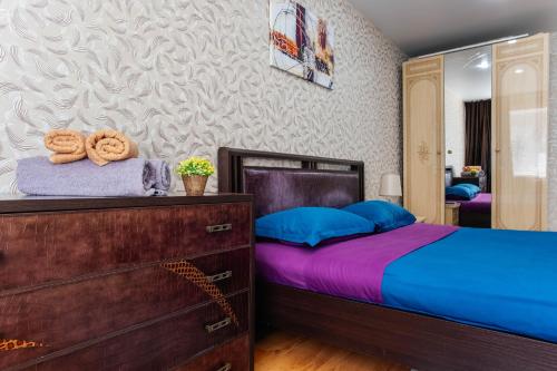 a bedroom with a bed and a dresser and a mirror at 1 комнатная квартира в центре на Пушкина 92 in Kostanay