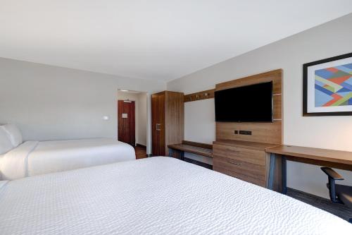 a hotel room with two beds and a flat screen tv at Holiday Inn Express & Suites - Brighton by IHG in Brighton