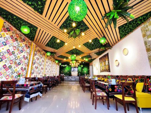 a restaurant with tables and chairs and a ceiling at Asem Hotel in Nukus
