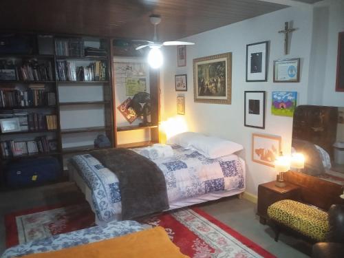 a bedroom with a bed and a book shelf at QUINTAS DA BARRA BNB a 30m da praia in Balneario Barra do Sul