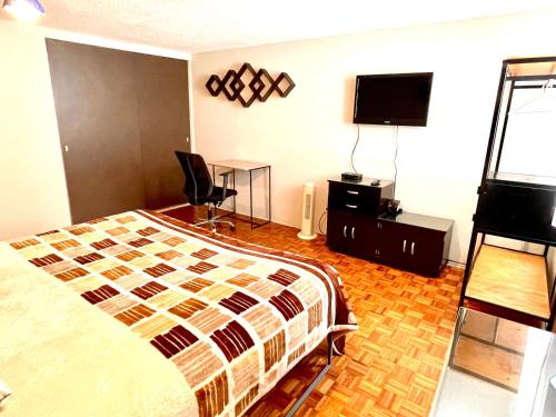 a bedroom with a bed and a flat screen tv at B&B México Roma Norte in Mexico City