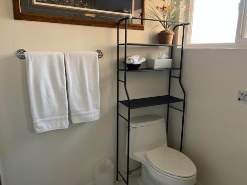 a bathroom with a toilet and towels on a wall at Casa Larrea Inn in Palm Desert