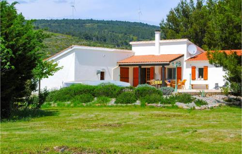 une maison blanche avec une cour devant elle dans l'établissement Cozy Home In Pouzols-Minervois, à Pouzols-Minervois