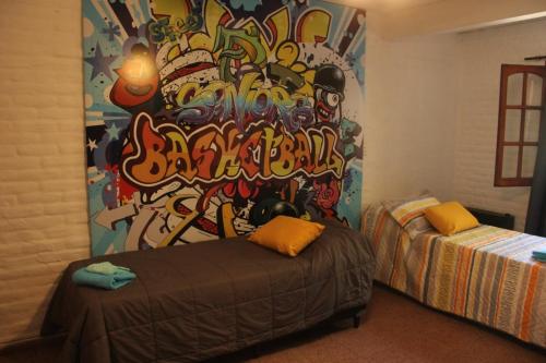 sypialnia ze ścianą pokrytą graffiti w obiekcie La Casa Nostra w mieście Río Cuarto