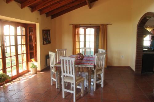 jadalnia ze stołem i białymi krzesłami w obiekcie La Casa Nostra w mieście Río Cuarto