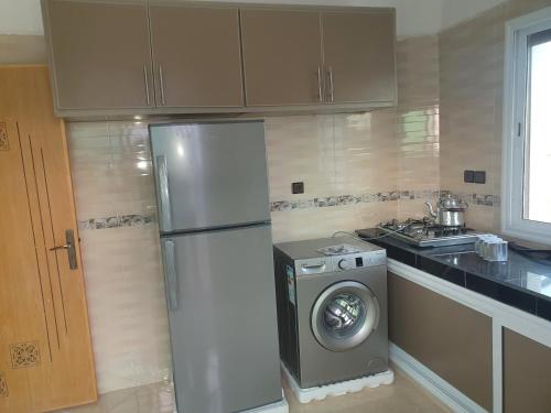 eine Küche mit einem Kühlschrank und einer Waschmaschine in der Unterkunft Appartement lala fatima in Fès