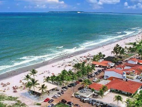 una vista aérea de una playa con palmeras y el océano en Praia de Guaibim - Casa de praia 2Q - 2 suítes com ar - em condomínio a 300m da praia, en Guaibim