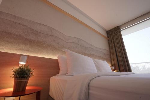 a hotel room with a bed and a window at Malaka Hotel Bandung in Bandung