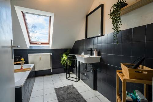 ein Bad mit einem Waschbecken und einem Spiegel in der Unterkunft STYLE-Apartment I Klimaanlage I WLAN I Küche I Smart-TV in Magdeburg