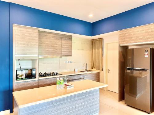 a kitchen with blue walls and a wooden counter top at Deco Home @ Imago The Loft in Kota Kinabalu