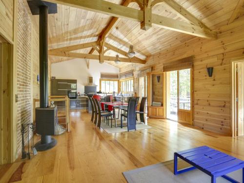 Il comprend un salon avec une salle à manger et une cuisine dotée de plafonds en bois. dans l'établissement Belle villa en bois 6 personnes avec terrasse et Wi-Fi à Biscarrosse - FR-1-521-71, à Biscarrosse