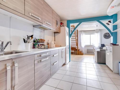 une cuisine avec des placards blancs et une poutre bleue dans l'établissement Charmant Studio Mezzanine - Hyper Centre Biscarrosse-Plage, Proche Océan - FR-1-521-114, à Biscarrosse-Plage