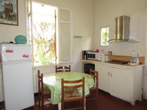 une petite cuisine avec une table et un réfrigérateur dans l'établissement Maison arcachonnaise à Biscarrosse Plage pour 6 pers. - FR-1-521-87, à Biscarrosse-Plage