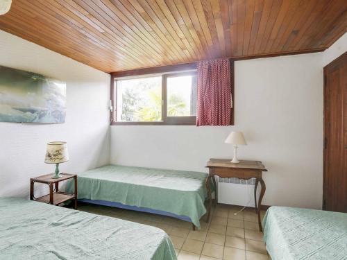 Cette chambre comprend 2 lits jumeaux et une fenêtre. dans l'établissement Maison atypique 7 pers, 2 terrasses, cheminée, à 1,5 km des plages et centre - FR-1-521-143, à Biscarrosse