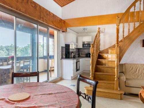 une cuisine et une salle à manger avec une table et un escalier dans l'établissement Duplex centre station Biscarrosse 6 pers, terrasse, WIFI, parking, équipements complets - FR-1-521-193, à Biscarrosse