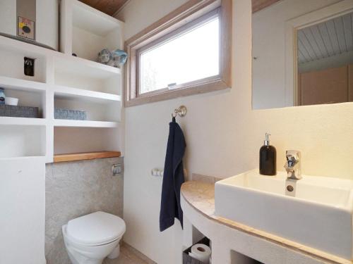 een badkamer met een wastafel, een toilet en een raam bij Holiday home Gilleleje XCV in Gilleleje