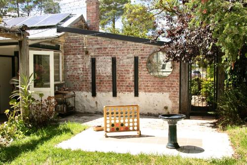 a bench in a yard next to a brick building at Rústicoq B+B in Cowaramup