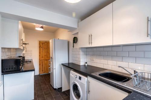 a kitchen with a sink and a refrigerator at Family & Contractors & Free Parking & Airport Location in Doncaster