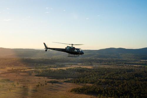 a helicopter flying in the sky over a field at Spicers Hidden Vale in Grandchester