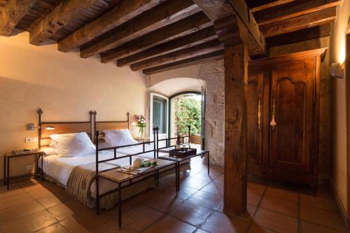 a bedroom with a bed and a table in a room at Hacienda Zorita Wine Hotel & Spa in Valverd&oacute;n