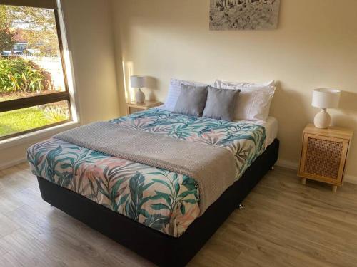 a bedroom with a bed and a window at Boyle's Beach House - Fully furnished 3 Bedroom home. Secure parking. in Nambucca Heads
