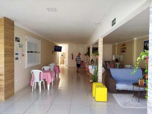 a living room with a couch and tables and chairs at Pousada Barreirinhas House in Barreirinhas