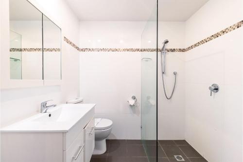 y baño blanco con ducha y aseo. en Shoalz Renovated Cottage and Boat Parking, en Shoal Bay