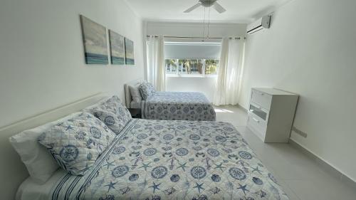 een slaapkamer met een bed, een bank en een dressoir bij Precioso Apartamento a solo pasos de la Playa in Punta Cana