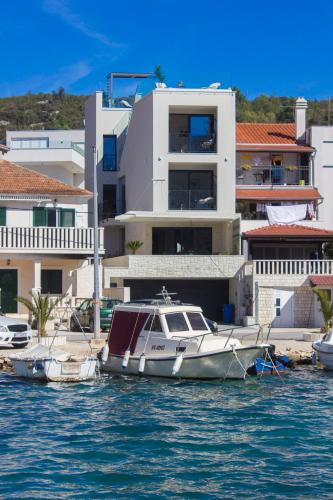 a boat docked in the water in front of buildings at Villa Lux in Vinišće