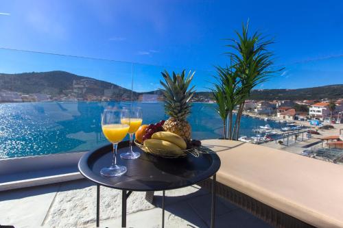 a table with a bowl of fruit and two glasses of wine at Villa Lux in Vinišće