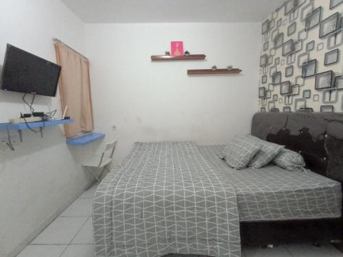 1 dormitorio con 1 cama y TV en Kuro House AT Aeropolis en Teko