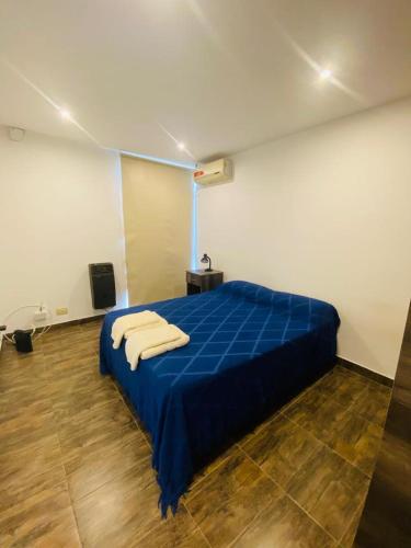 a bedroom with a blue bed with towels on it at Enjoy Apart Campana in Campana