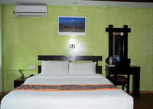 Dormitorio con cama grande, escritorio y cama sidx sidx en Panoramic apartment in peaceful location of Thamel, en Katmandú
